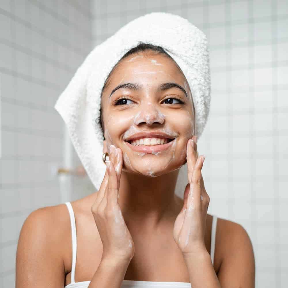 lady washing her face after washing her hair