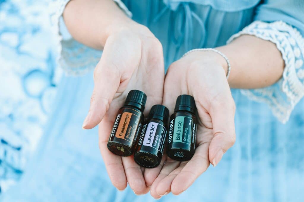 Three essential oils for acne in the palm of a ladies hand