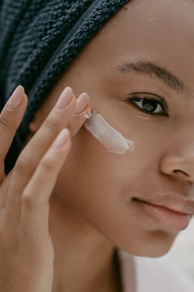 Woman Putting Face Cream on Cheek completing her natural anti-aging skincare routine