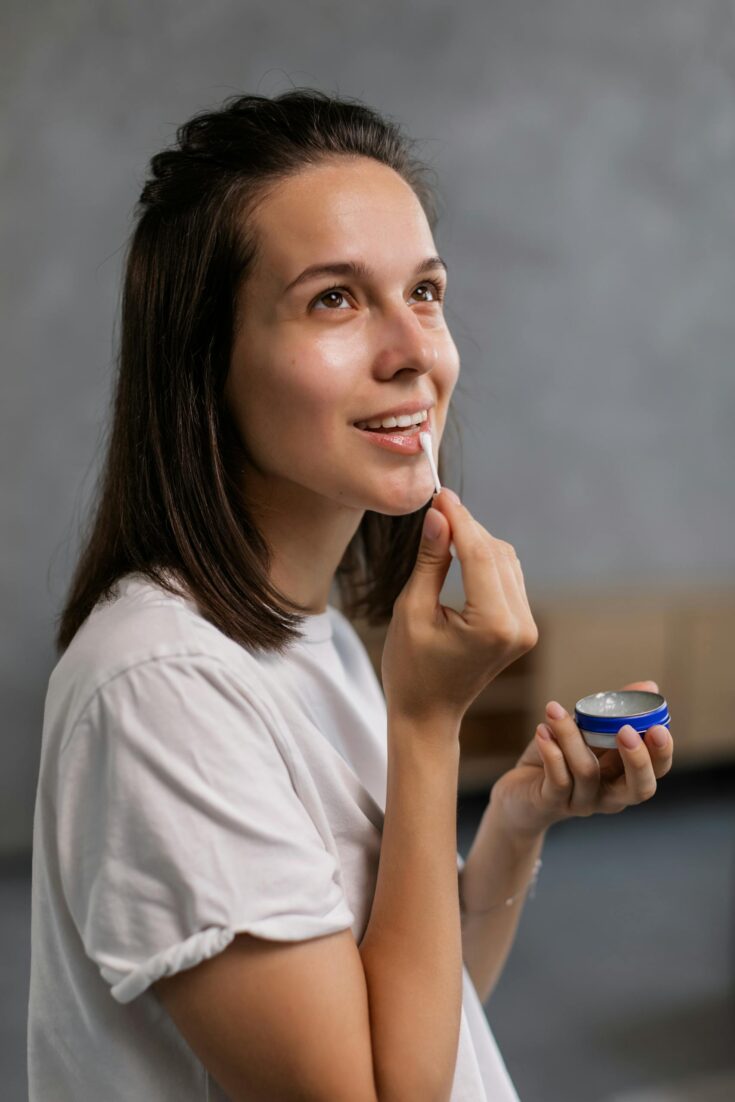 A Woman Applying a Lip Balm