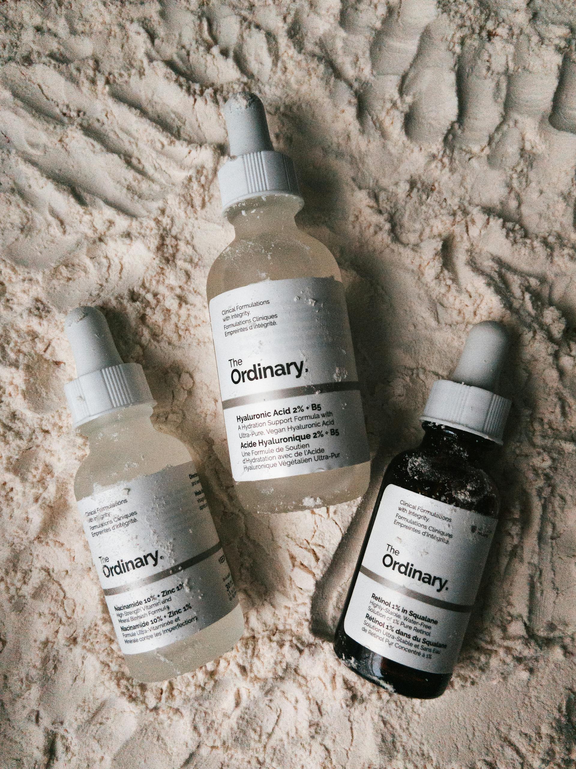 Dropper Bottles of Skincare Products from The Ordinary Lying on Talcum Powder