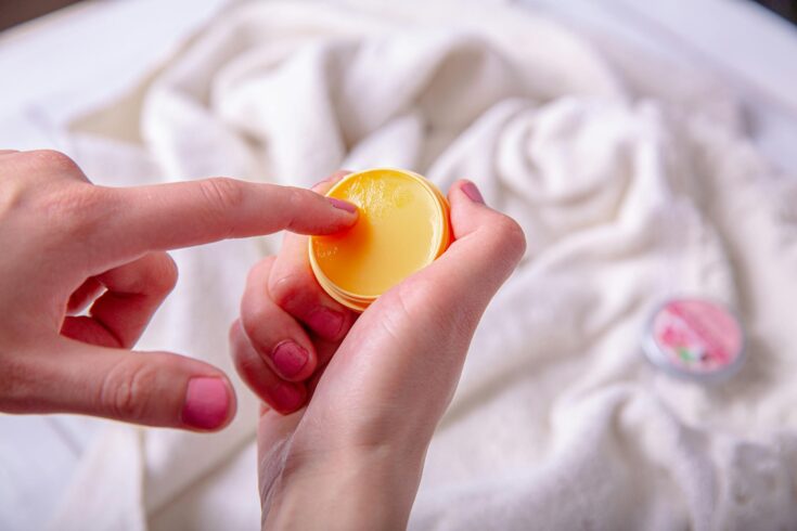 Woman Taking a Lip Balm Cream on Container