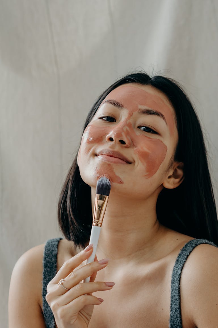 A Beautiful Woman Applying Clay Mask on Her Face