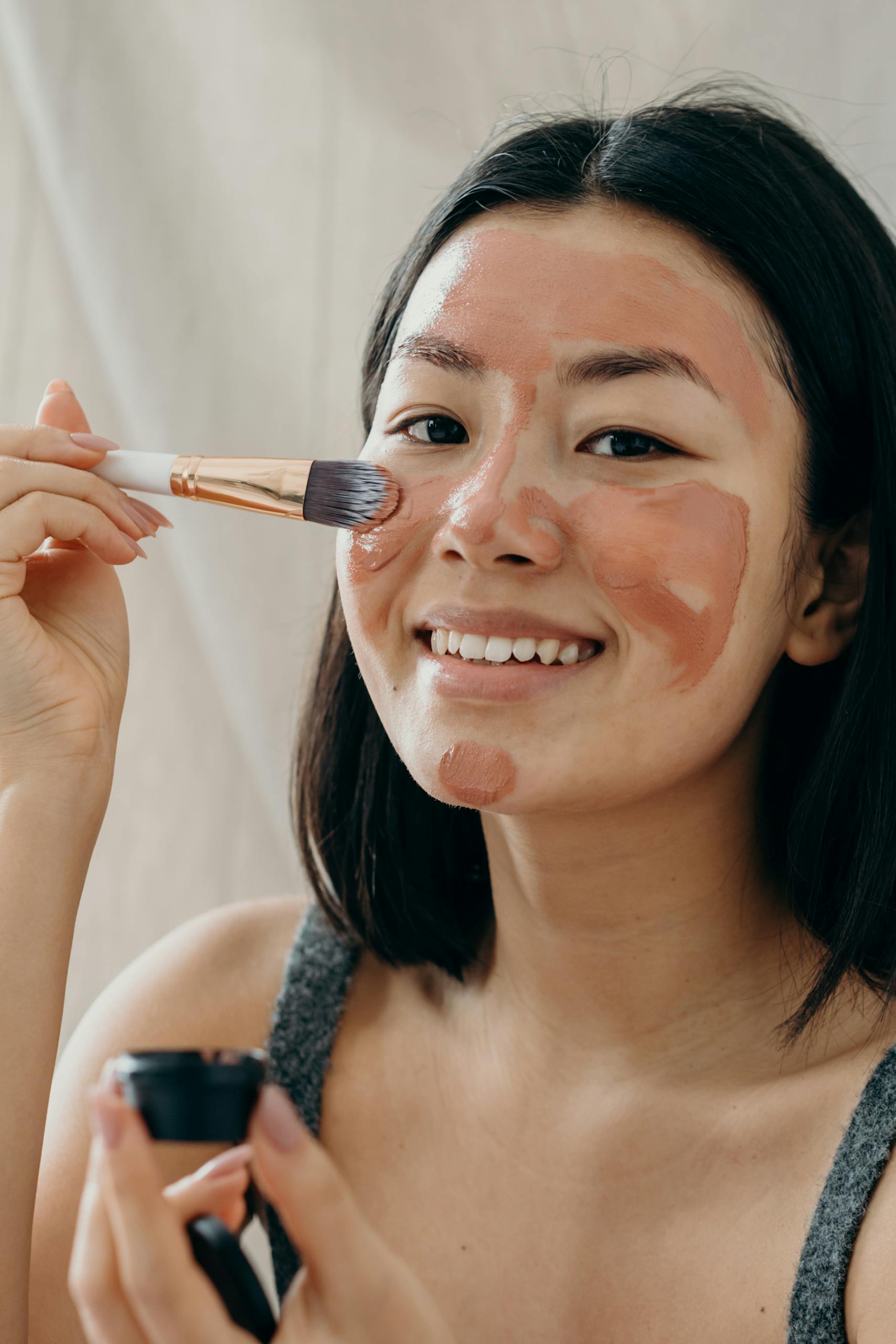 A Woman Applying Clay Mask on Her Face Using Makeup Brush