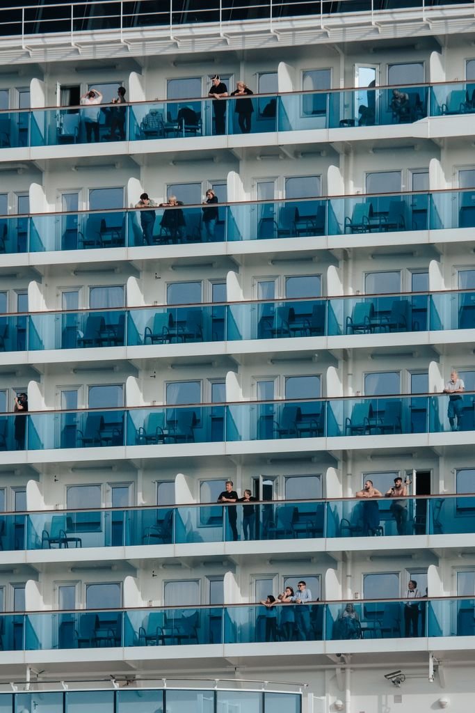 Close-up of cruise ship balconies with people enjoying the view, showcasing modern luxury travel.